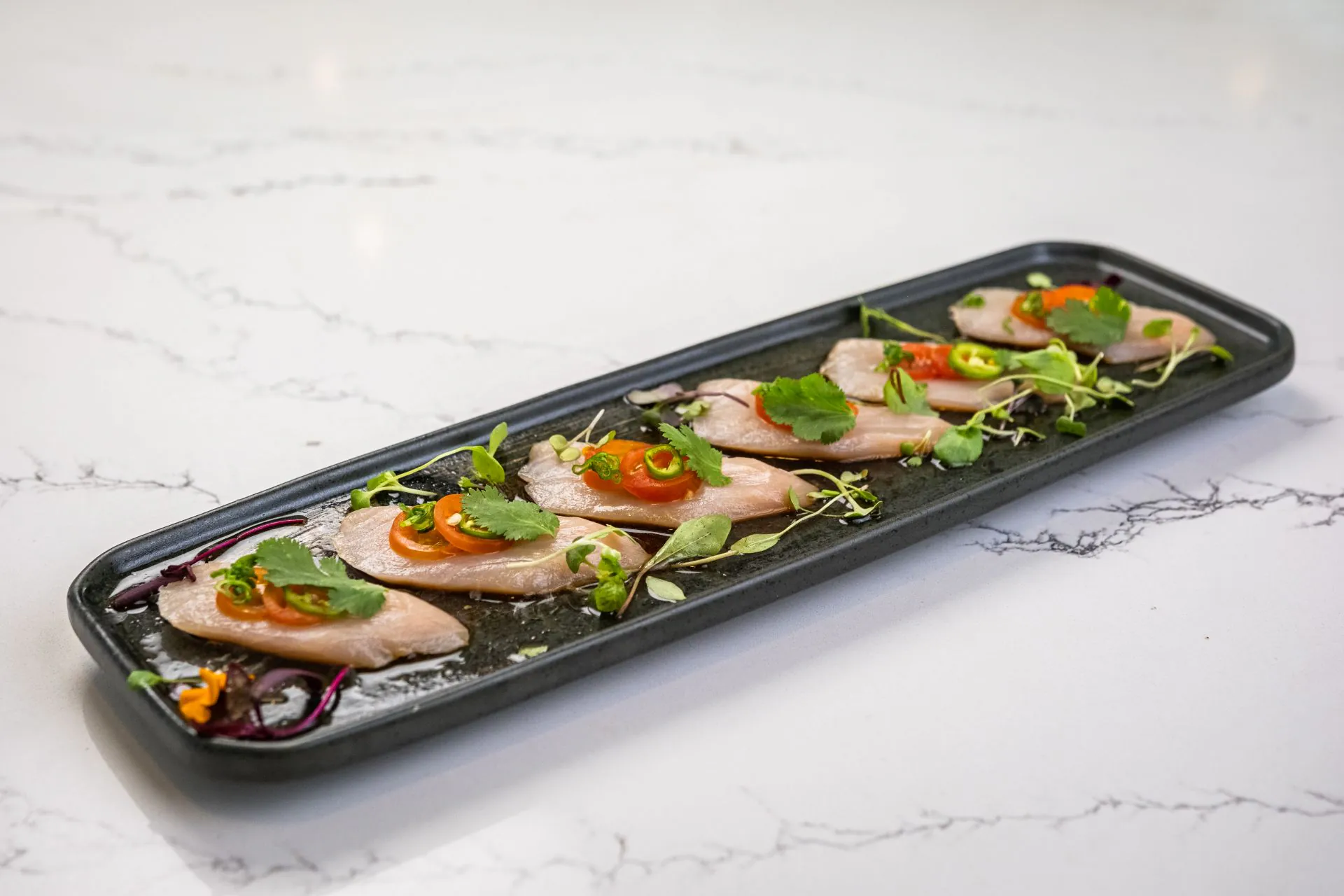 White fish carpaccio with chili, cilantro and microgreens at Toki Ramen & Sushi, a Japanese Restaurant in Denver